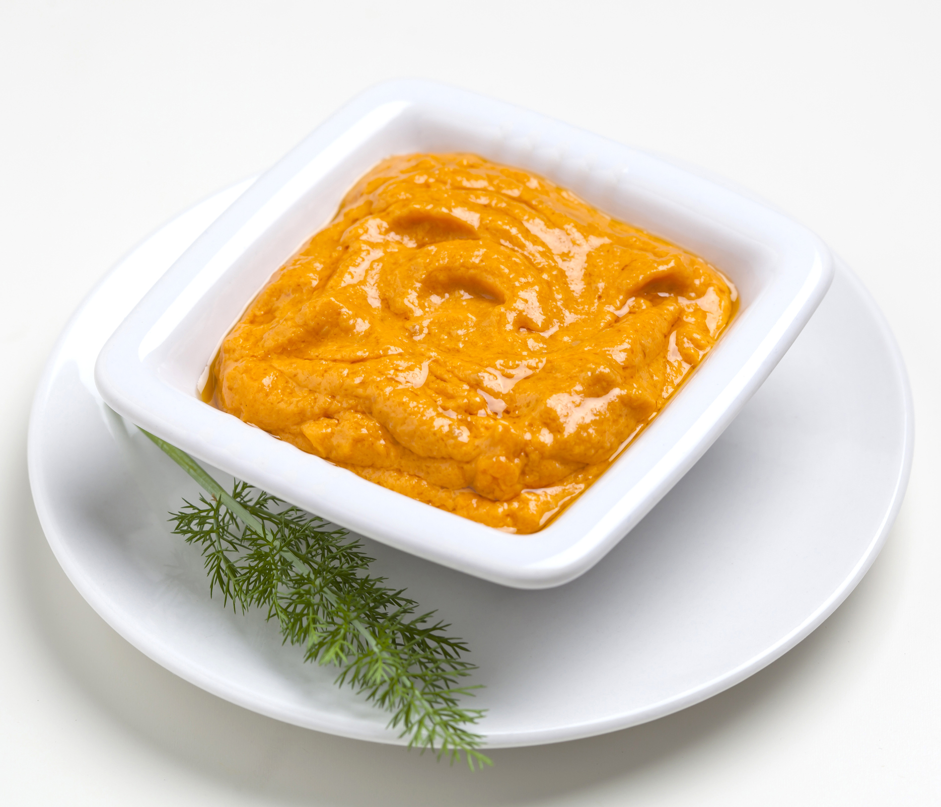 Orange-colored chutney dipping sauce with dill herb spring