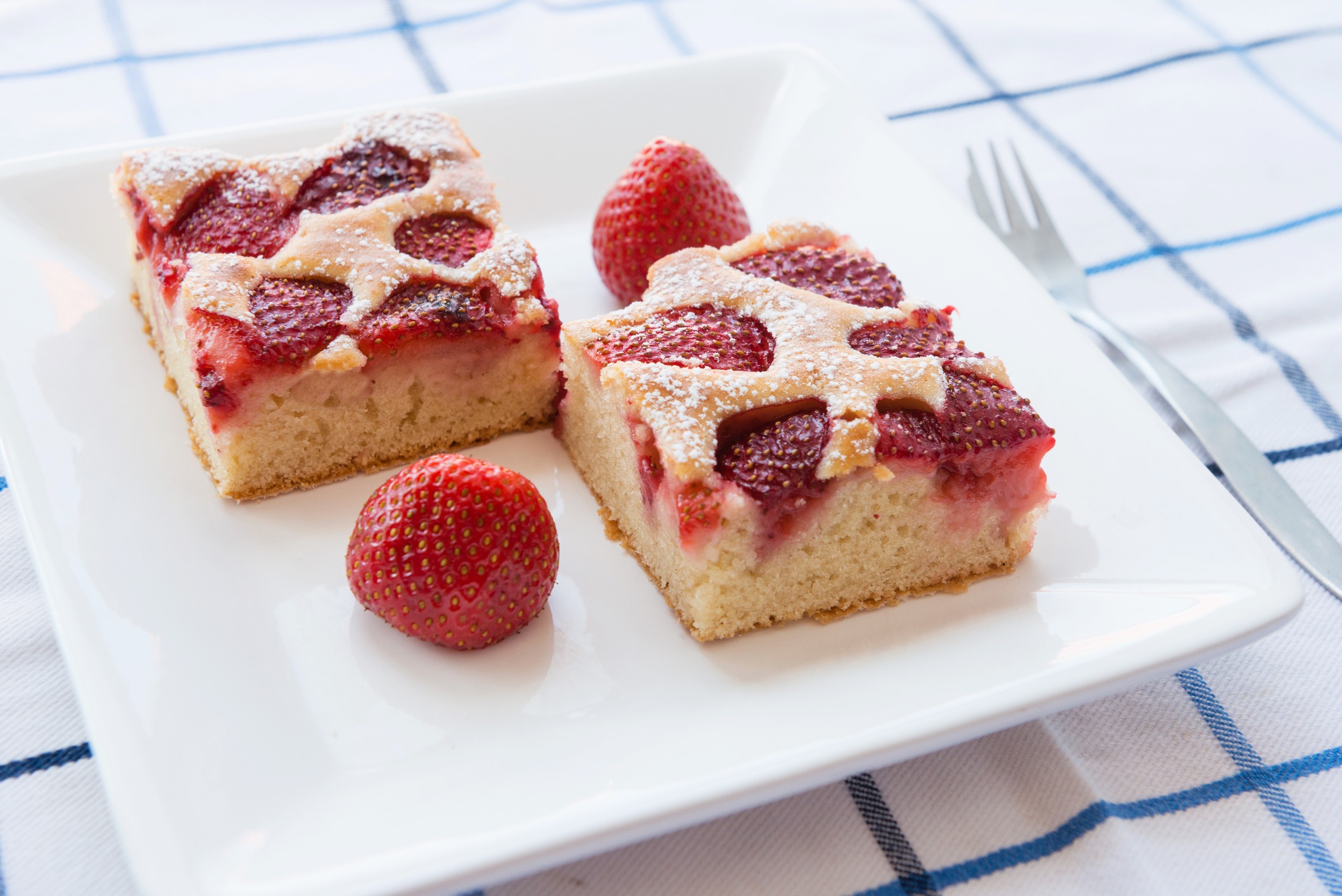 strawberry cake with fresh strawberries served on white plate