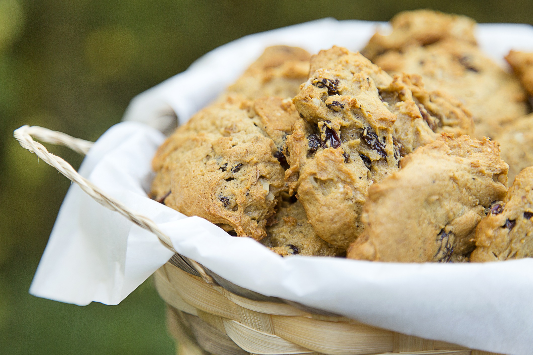 Basket of Persimmon Cookies with Raisins resting on a white napkin.